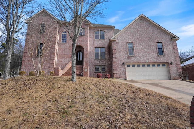 traditional home featuring a garage, driveway, and brick siding