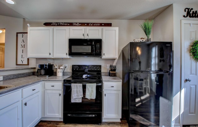 kitchen with black appliances, light countertops, and white cabinetry