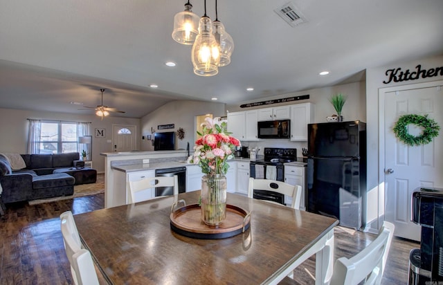 dining room with dark wood-type flooring, recessed lighting, visible vents, and vaulted ceiling