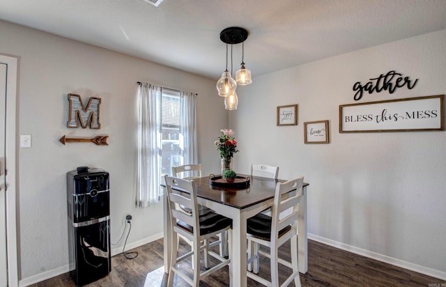 dining area featuring dark wood-type flooring and baseboards