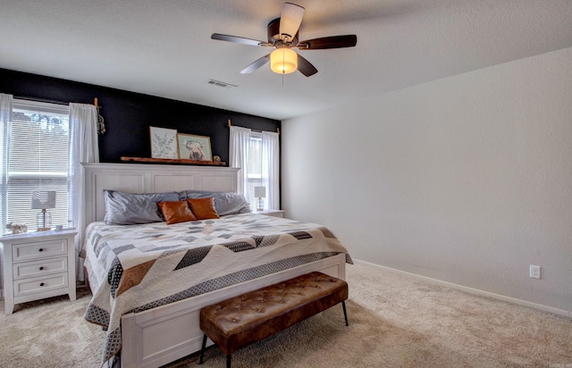 bedroom featuring light carpet, a ceiling fan, visible vents, and baseboards