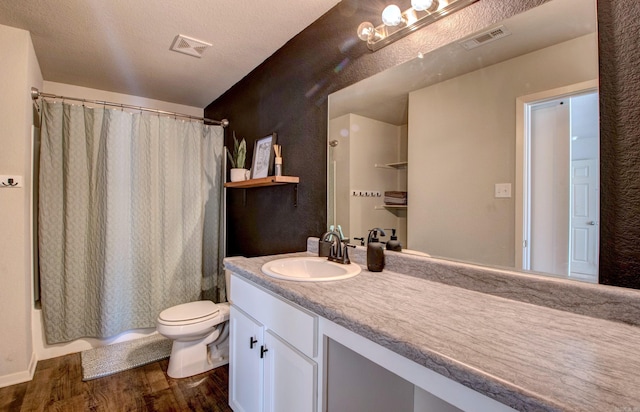 full bathroom featuring toilet, vanity, wood finished floors, and visible vents