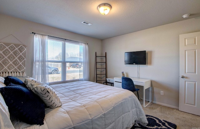 bedroom featuring light carpet, a textured ceiling, visible vents, and baseboards