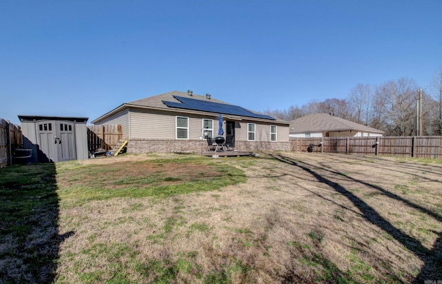 back of property featuring a storage shed, an outbuilding, and a fenced backyard