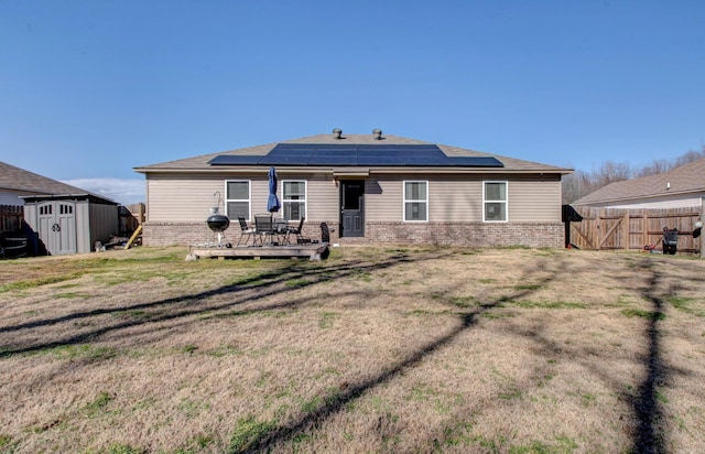 back of house with a storage shed, a fenced backyard, an outdoor structure, and brick siding