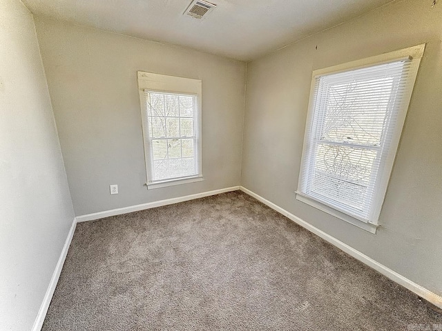 carpeted empty room featuring visible vents and baseboards