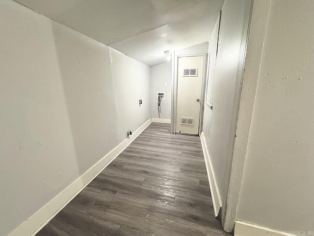 corridor with baseboards, visible vents, vaulted ceiling, and wood finished floors