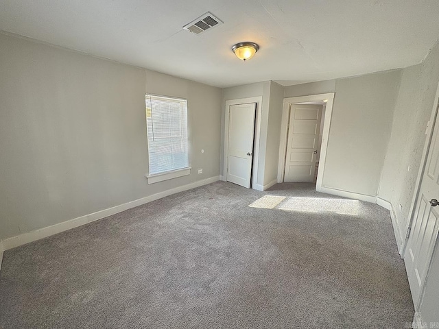 unfurnished bedroom featuring carpet, visible vents, and baseboards