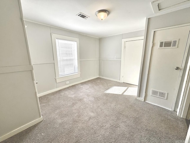 empty room with baseboards, visible vents, and carpet flooring