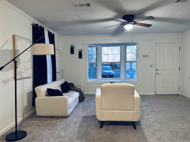 carpeted living room featuring a textured ceiling, ornamental molding, visible vents, and baseboards