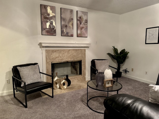 sitting room featuring a textured ceiling, carpet floors, a high end fireplace, and baseboards