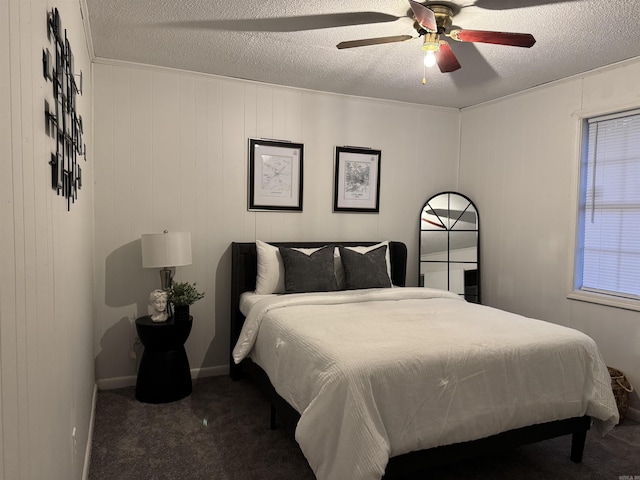 carpeted bedroom featuring ceiling fan, baseboards, and a textured ceiling