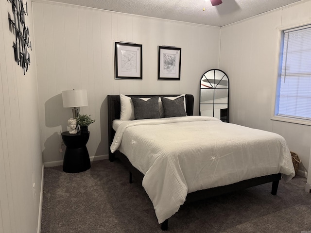 bedroom with a ceiling fan, carpet flooring, a textured ceiling, and baseboards