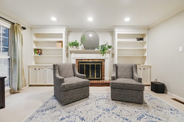 sitting room featuring carpet floors, built in shelves, a brick fireplace, and crown molding