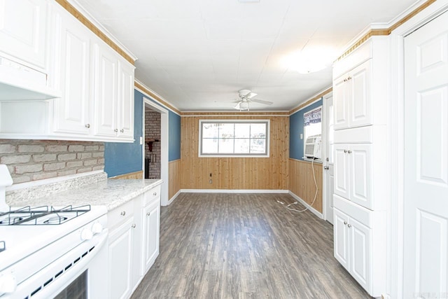 kitchen featuring white range with gas cooktop, baseboards, ceiling fan, wood finished floors, and white cabinetry