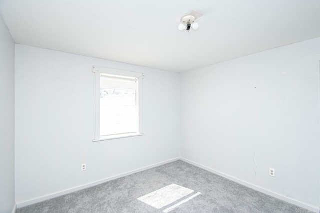 carpeted spare room with baseboards