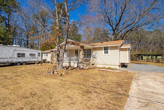 view of front of house with driveway, a porch, and a front yard