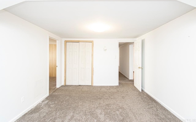 unfurnished bedroom with a closet, carpet flooring, and baseboards