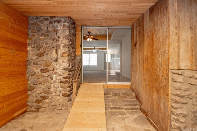 hall with wood ceiling and wooden walls