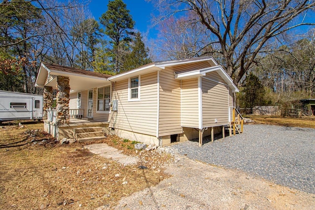 view of front facade featuring gravel driveway and covered porch