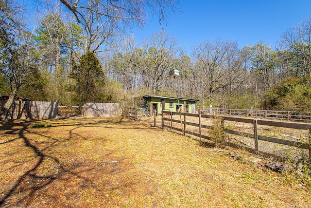 view of yard featuring an outdoor structure and fence