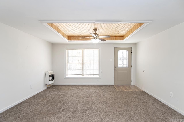 foyer with carpet flooring, wood ceiling, baseboards, heating unit, and a tray ceiling