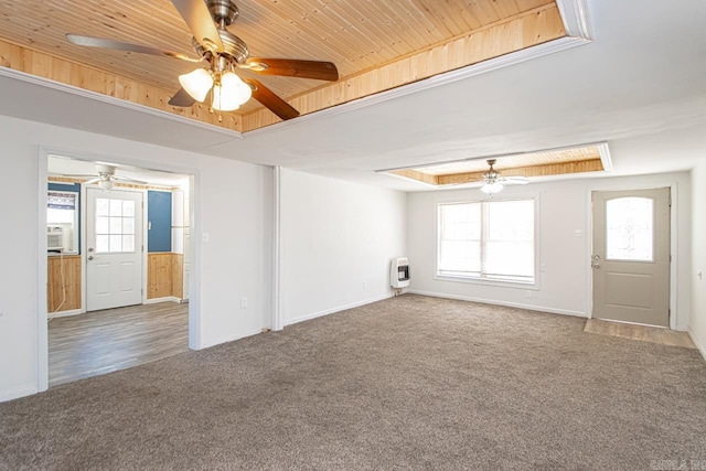 unfurnished living room with carpet floors, a tray ceiling, heating unit, a ceiling fan, and wooden ceiling