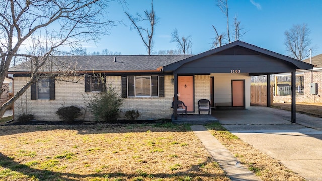 single story home with a carport, brick siding, and a front lawn