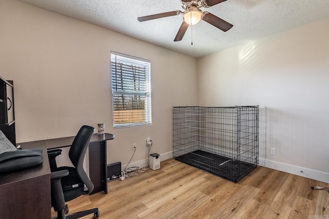 office with a textured ceiling, wood finished floors, a ceiling fan, and baseboards