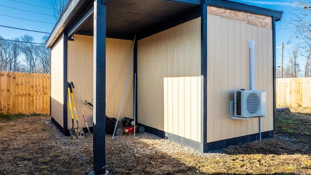 view of outbuilding featuring ac unit, fence, and an outbuilding