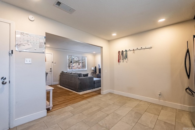 hall with light wood-style floors, baseboards, visible vents, and recessed lighting