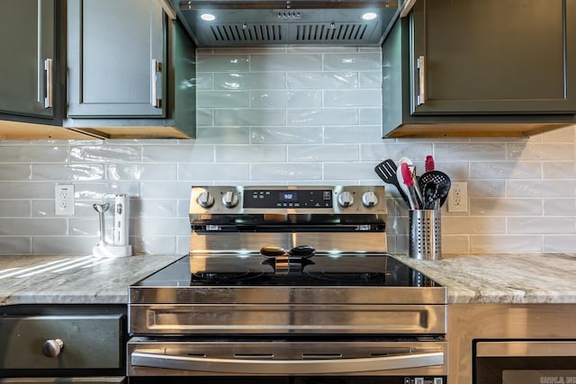 kitchen featuring light stone counters, backsplash, stainless steel electric range, and custom exhaust hood