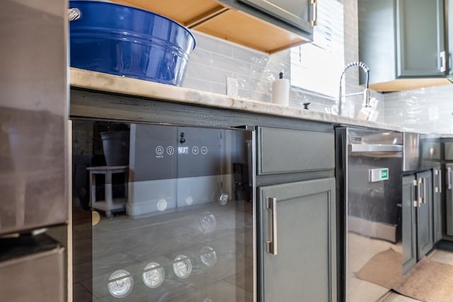 kitchen featuring tasteful backsplash, a sink, light stone counters, and light tile patterned floors