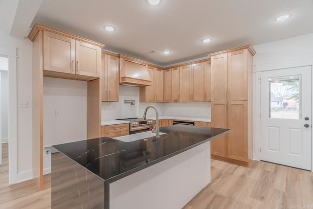 kitchen featuring custom range hood, light wood-style flooring, light brown cabinets, a sink, and stainless steel range with electric stovetop