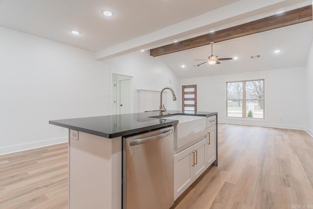 kitchen featuring a center island with sink, lofted ceiling with beams, open floor plan, stainless steel dishwasher, and a sink