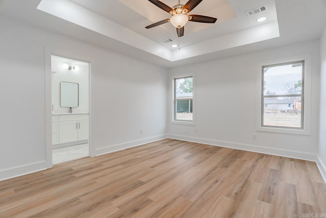 empty room with visible vents, baseboards, and a raised ceiling