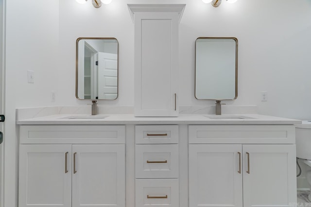 full bath featuring a sink, toilet, and double vanity