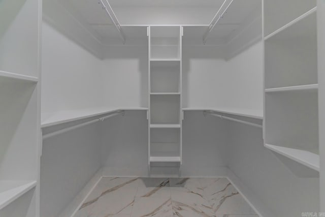 walk in closet with marble finish floor