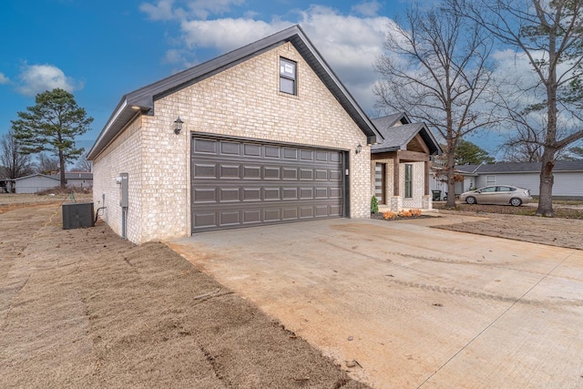 view of home's exterior with a garage, central AC, brick siding, a shingled roof, and concrete driveway