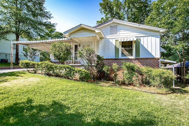 view of front of home featuring a carport, a front lawn, and brick siding