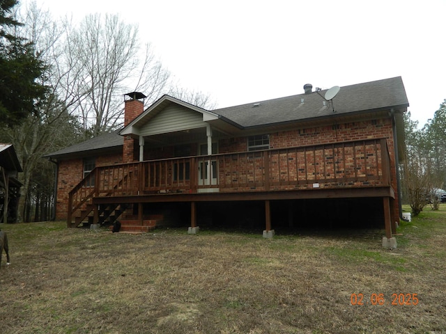 rear view of property featuring a deck, brick siding, a lawn, and a chimney