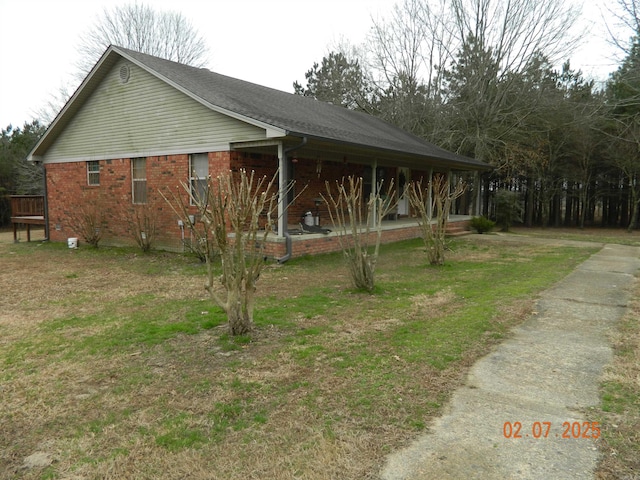 view of side of property with brick siding and a yard