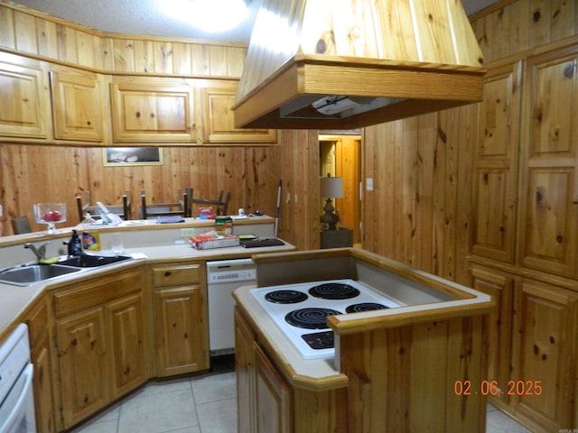 kitchen with light tile patterned floors, light countertops, white appliances, and a sink