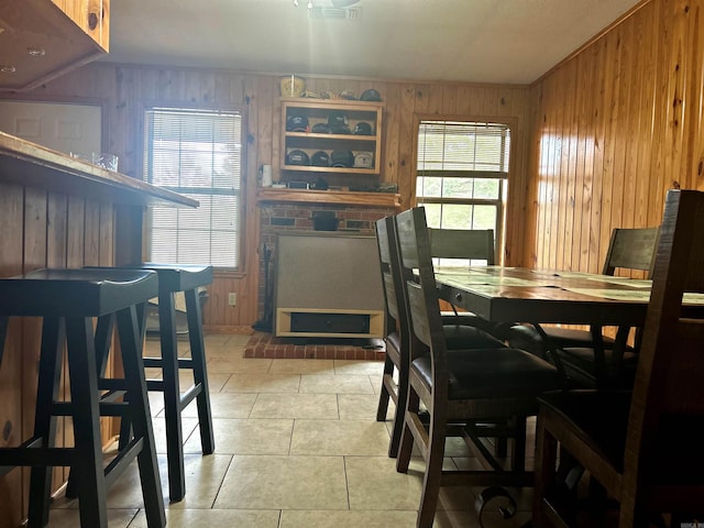 dining room featuring tile patterned flooring and wooden walls