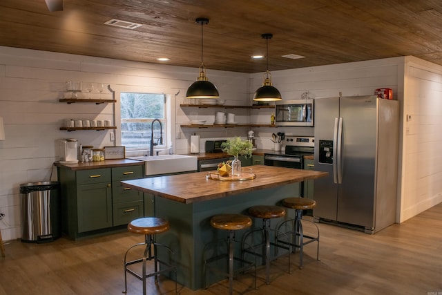 kitchen with wooden counters, appliances with stainless steel finishes, open shelves, and green cabinetry