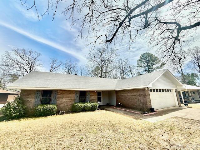 ranch-style home with a garage, brick siding, and driveway