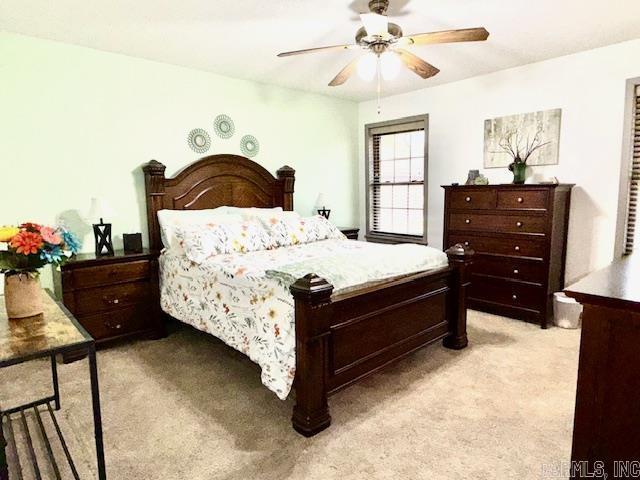 bedroom with a ceiling fan and light colored carpet