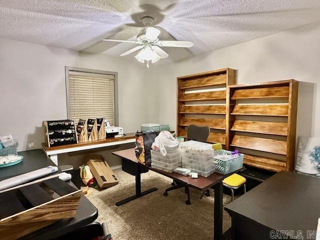 home office with a textured ceiling, carpet, and a ceiling fan