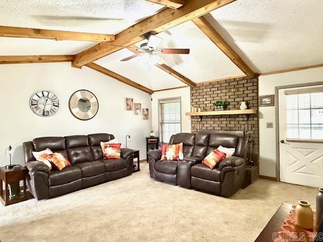 carpeted living room with a healthy amount of sunlight, a textured ceiling, and lofted ceiling with beams