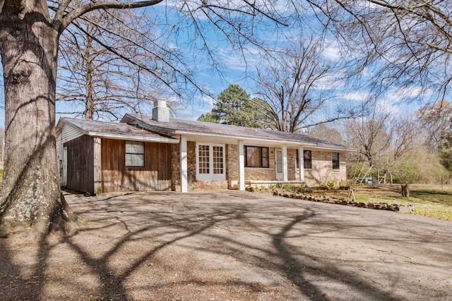 ranch-style house with aphalt driveway and a chimney